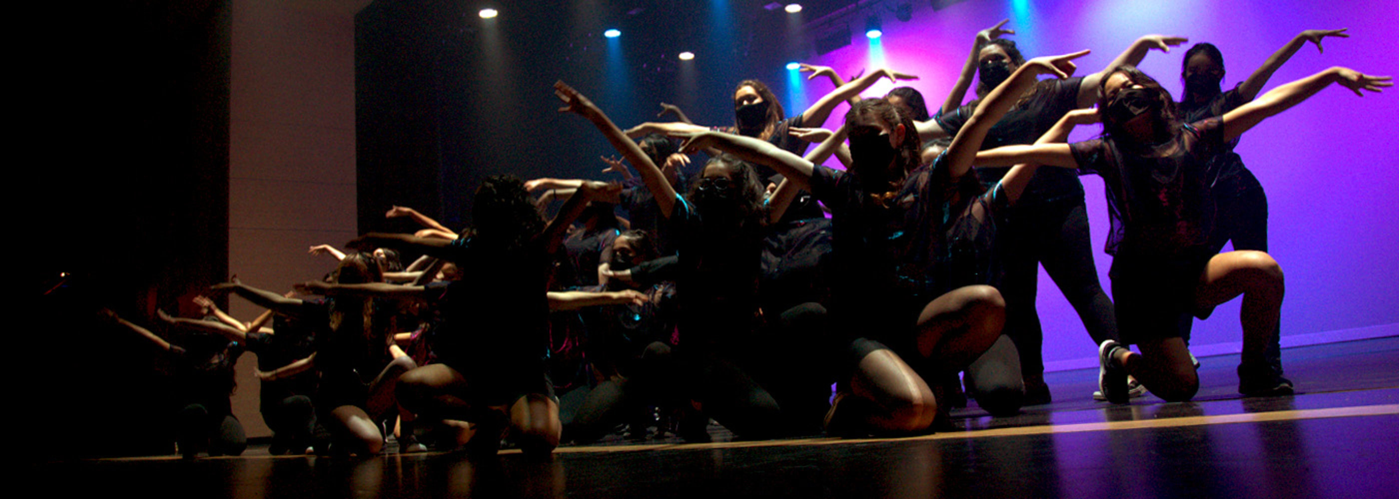 Dancers on stage smiling for camera